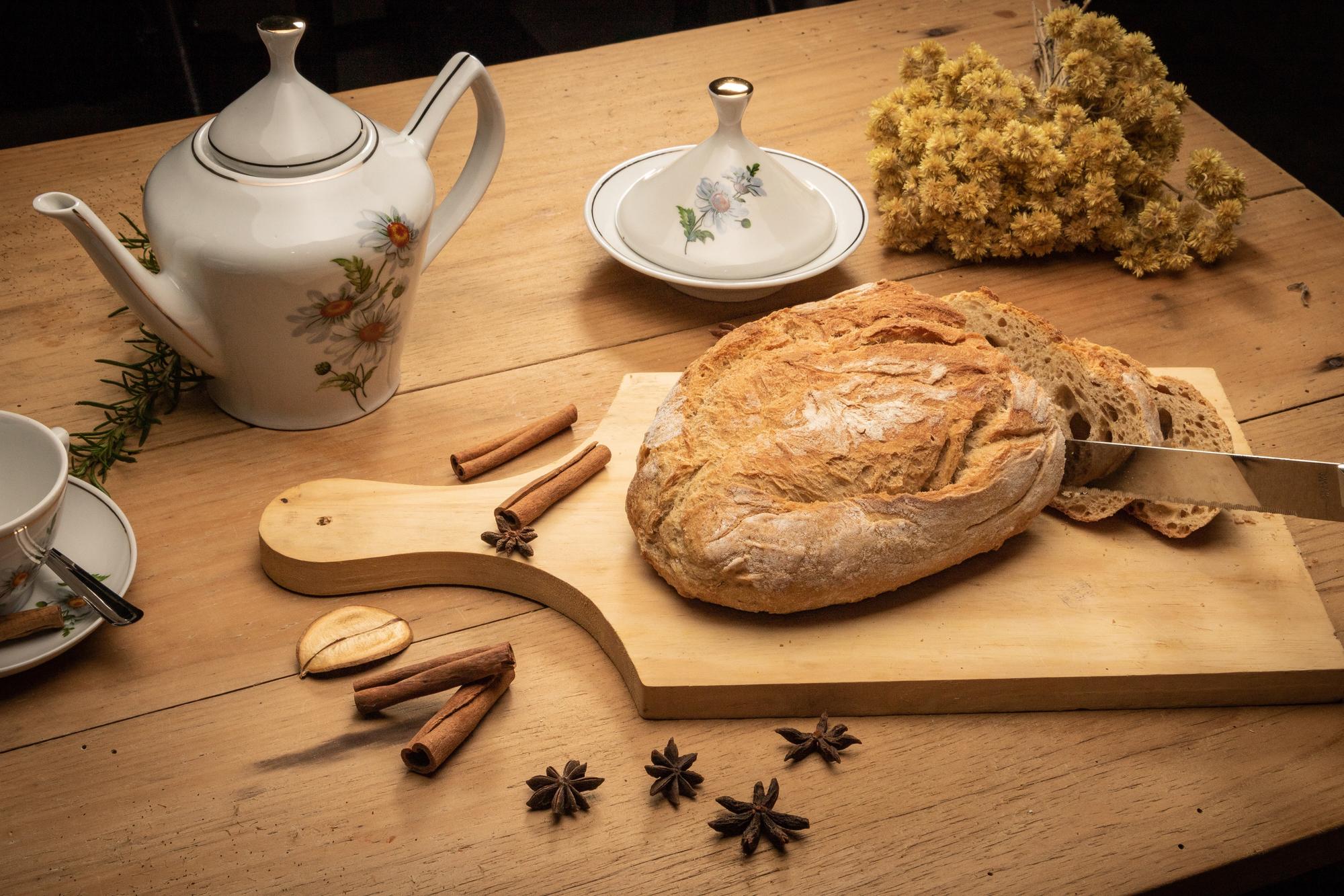 Close-up of artisan bread and preserved herbs on rustic table