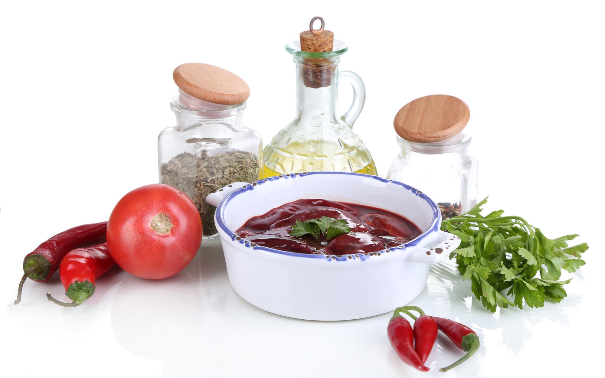 Close-up of simmering sauce and herbs in pan